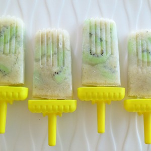 Creamy pear popsicles with chunks of kiwi and yellow sticks